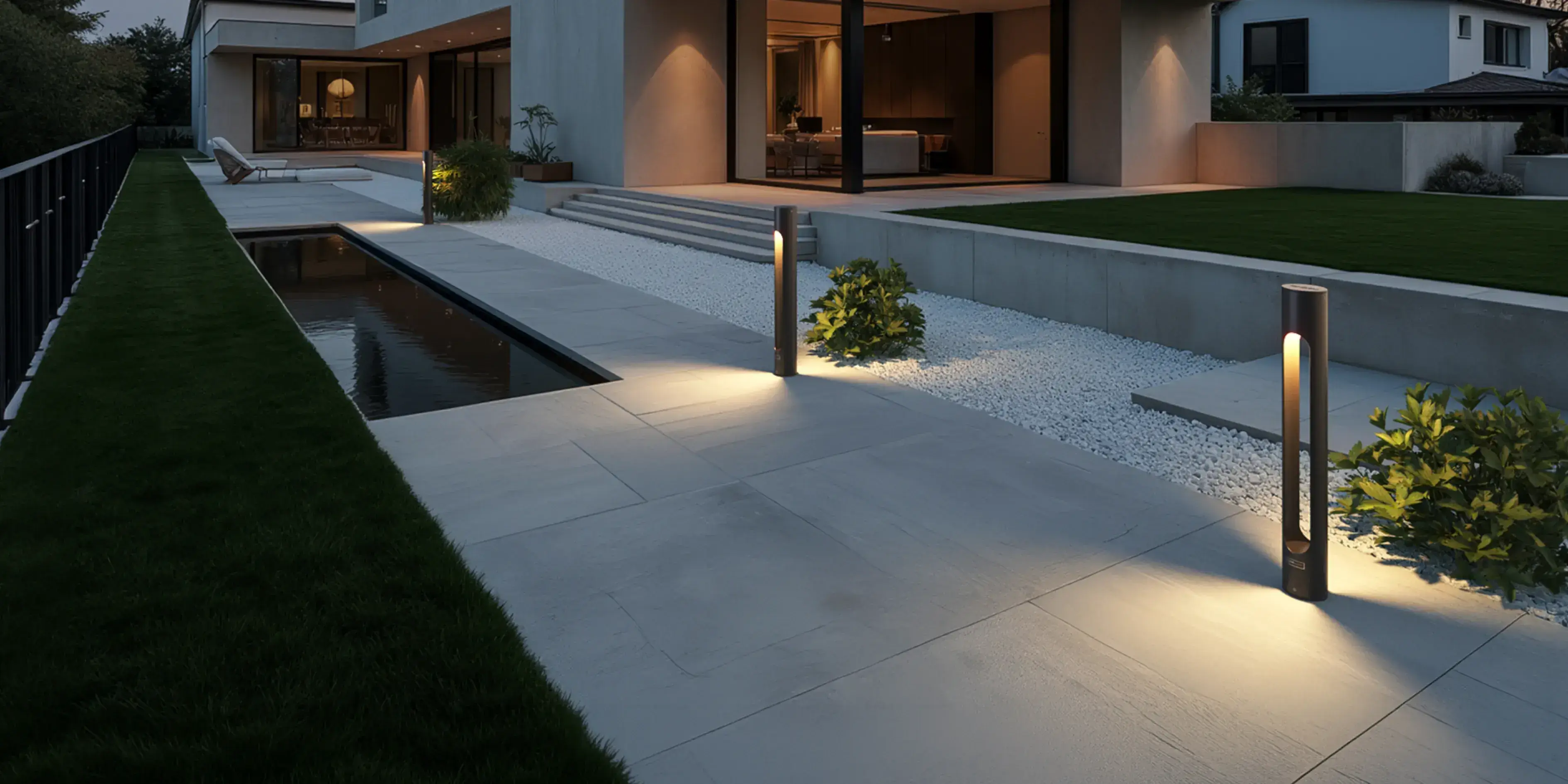 Alacakaranlıkta taş patikayı aydınlatan Fonelight Velora bollard armatürleri