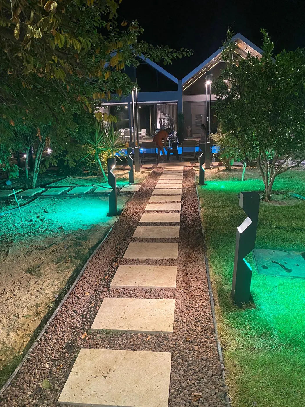 Geceleyin özel bir bahçedeki taş patika boyunca renk değiştiren bollard armatürler