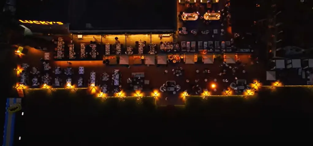 Aynı sahil terasının gece, uçtan uca aydınlatılmış kuşbakışı görünümü